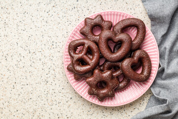 Sweet chocolate hearts, stars and pretzels on plate.
