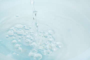 a jet of water pours into a container of water. 