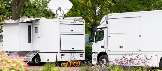Many modern white mobile digital electric tv broadcasting trucks satellite antenna live streaming...