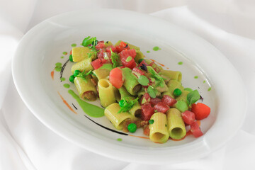 Paccheri pasta with vegetables and cheese on a white background, gourmet cuisine, vegetarian dish, concept of a healthy Mediterranean diet, close-up.