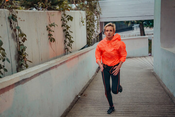 Women in sports clothes running in a modern urban environment et night time. The concept of a...