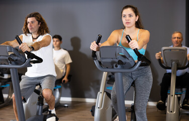 Fototapeta na wymiar Mature man doing cardio workout out at gym, training on exercise bikes