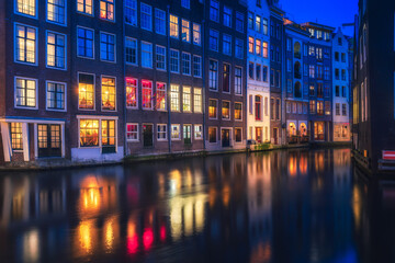 Fototapeta na wymiar Amsterdam night, red light district night with colorful windows near the basilica of saint nicholas