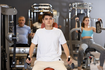 Young athlete is engaged in a power simulator in the gym