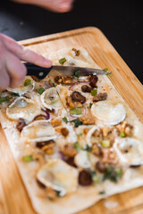 Vegetarischer Flammkuchen auf einem Holzbrett