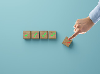 Wooden cubes with a green acceptance mark, and a sliding red cube with a cross. The concept of...