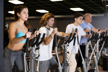 Fototapeta na wymiar Race walking on elliptical trainers in a modern gym