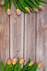 Pink and yellow tulips on a wooden background with a place for text. International Women's Day, March 8, Mother's Day, Valentine's Day.  Copy space. Mothers day background. Space for text.