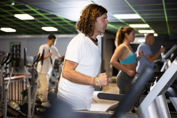 Athletic man exercising on a treadmill in the gym