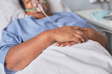 Close up of hands of black woman on bed in hospital room, copy space