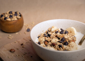 Healthy Breakfast Bowl With Granola, Yogurt, Banana and chocolate chips.