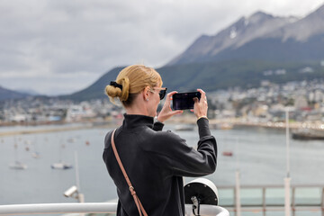 Young woman taking a photograph in Ushuaia Argentina
