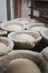 Round shaped bread doughs proofing in banneton basket in a bakery