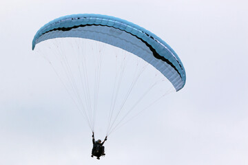 Paraglider flying in a cloudy sky	