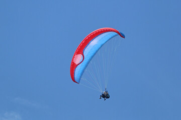 Tandem Paraglider flying in a blue sky