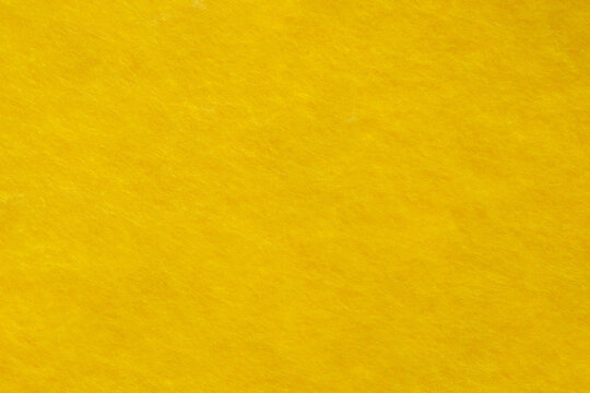 Fabric is fleece non-woven yellow, background wallpaper, uniform texture pattern
