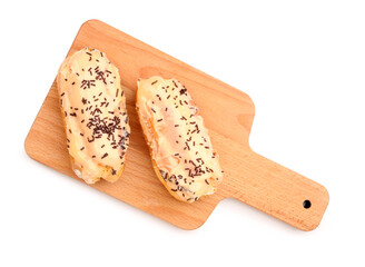 Board with sweet eclairs isolated on white background