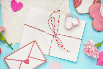 Composition with envelopes, sweet cookies and carnation flowers on color background, closeup. Valentine's Day celebration