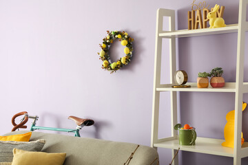 Easter wreath hanging on lilac wall in interior of living room