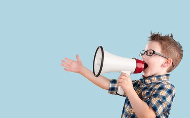 Happy young boy posing, screaming on megaphone.