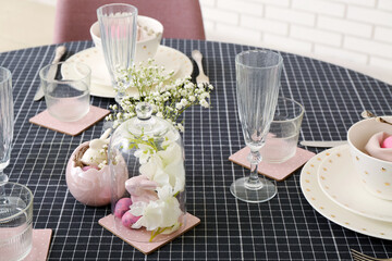 Festive table setting with painted eggs, bunnies and flowers served for Easter celebration