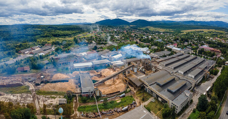 Aerial view of wood processing plant with smokestack from production process polluting environment...