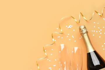 Composition with bottle of champagne, glasses and serpentine on orange background