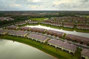 View from above of densely built residential houses near retention ponds in closed living clubs in south Florida. American dream homes as example of real estate development in US suburbs