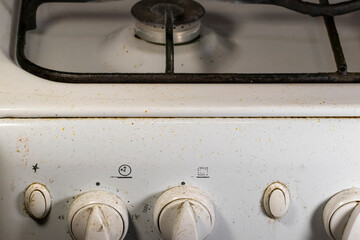 Dirty gas stove.Dirty control buttons on a white gas stove. The concept of cleaning in the kitchen.
