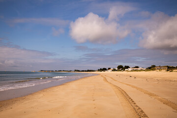 Fototapeta na wymiar Seascape with the beach near the bridge called Pont de l'île de Ré. Kite surfers sail the ocean