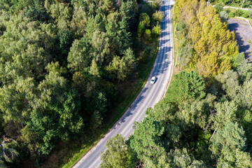 View from above on a smooth bend of the road going through the forest area