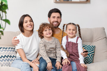 Happy family watching TV on sofa indoors