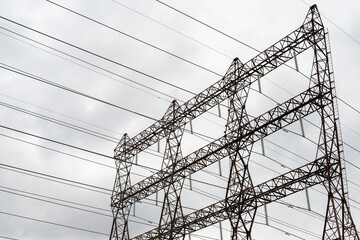 An electric utility pole with electrical wires, transmission lines, conductors, and distribution...