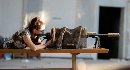 female sniper with a rifle in an abandoned building.