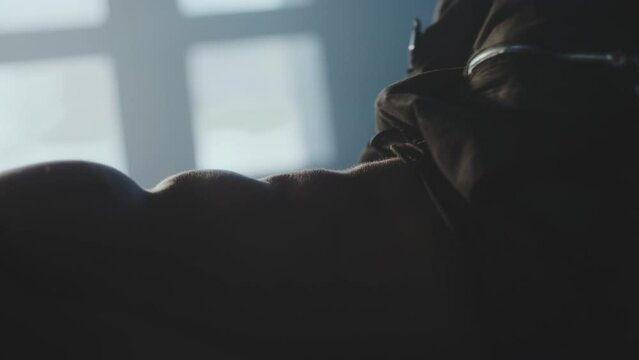 Handsome athlete with six pack lying on the floor mat, doing sit-ups fat burning workout in fitness gym. Shot in slow-motion