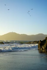 Behang Baker Beach, San Francisco Birds flying over Baker Beach in San Francisco, CA