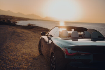 convertible at sunset by the sea