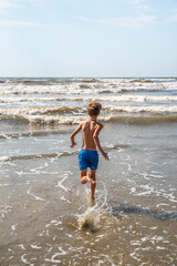 Youth Child Preteen Boy Running into the Ocean Waves on the Beach