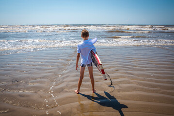 Youth Child Preteen Boy Standing on the Beach with A Boogie Board 