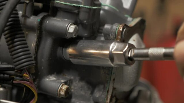 Removing spark plug from outboard engine