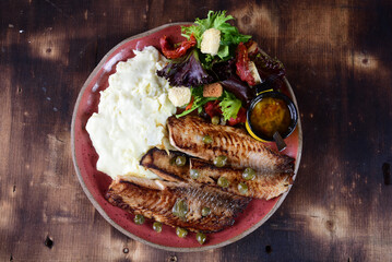 fried fish fillet with boiled mashed potatoes and salads