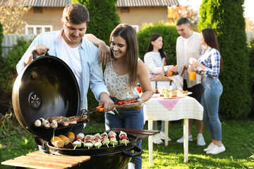 Group of friends having barbecue party outdoors
