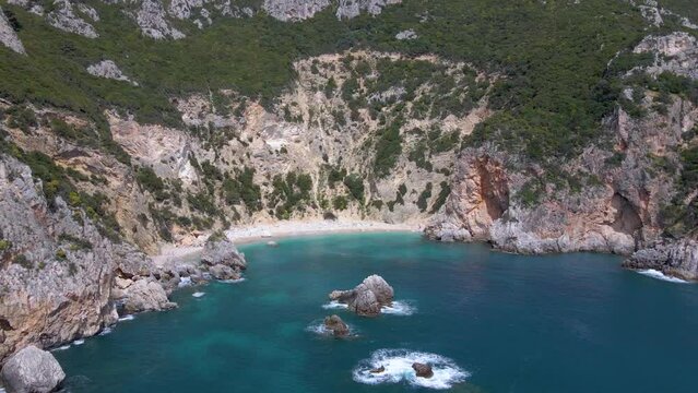 Aerial, approaching pebble cliff beach with no people on Corfu, Greece, slow-motion