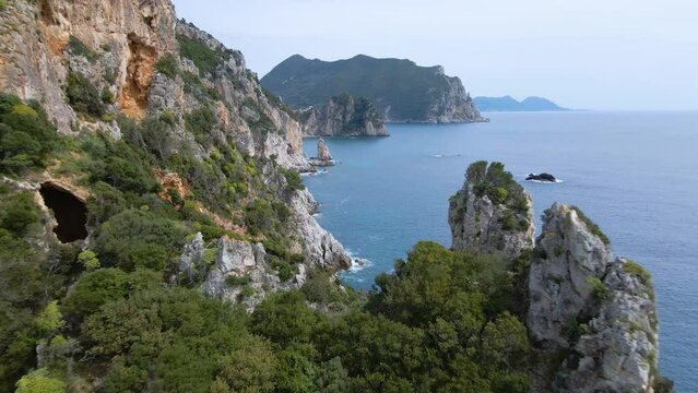 Aerial, flying close over cliff revealing rocky coastline on Corfu, Greece, slow-motion