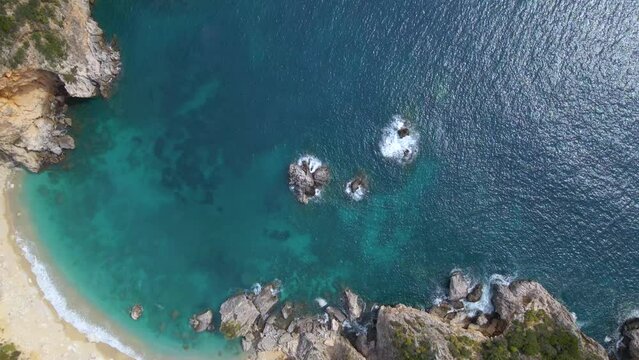 Aerial, top down, rotating view of rocky cliff beach with no people, Corfu, Greece, slow-motion