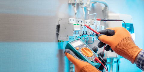 Electrician measure voltage and current in electrical panel. horizontal banner with copy space.