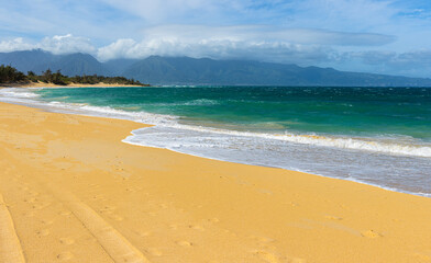 Fototapeta na wymiar Beautiful Sand and Waves on Baldwin Beach With The West Maui Mountains, Maui, Hawaii, USA