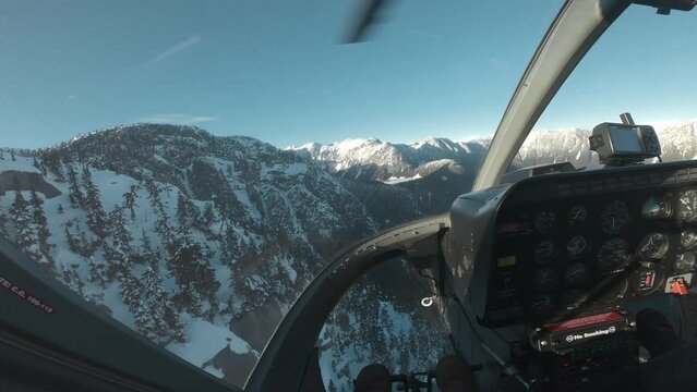 POV of a guy taking photos in the front seat of a helicopter in Canada, BC