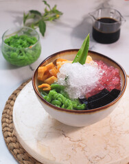 Es Campur. Icy Asian dessert of red ruby pearls, jelly bubbles, noodle jelly, and basil seeds in sweet coconut milk soup.
