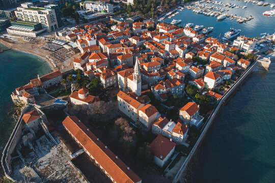 View of Budva old town, Budva Municipality and Riviera, resort on the Adriatic sea coast, Montenegro, sunny day with a blue sky, aerial drone view with beach and mountains, travel to Montenegro